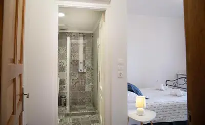a small bathroom with a shower and a bed at Belvedere private luxury beach villa in Halki