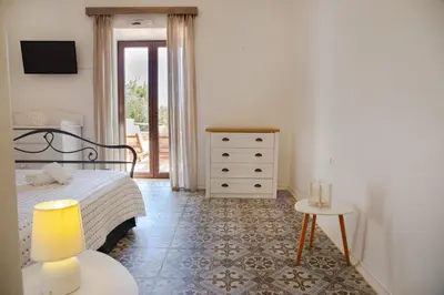 a bedroom with a bed and a table and a dresser at Belvedere private luxury beach villa in Halki