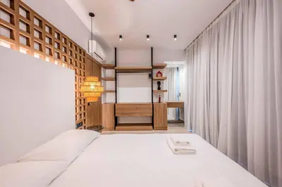 a bedroom with a large bed and a desk at Alati Suites - Stegna Beach in Vrachonisída touArchangélou