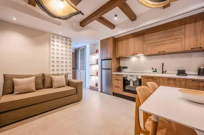 a kitchen and living room with a couch and a table at Alati Suites - Stegna Beach in Vrachonisída touArchangélou
