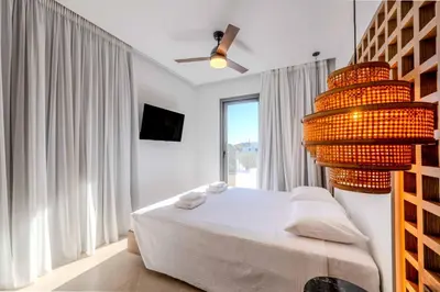 a bedroom with a bed and a large window at Alati Suites - Stegna Beach in Vrachonisída touArchangélou