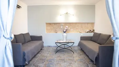 a living room with two couches and a table at Villa Romanza beach villa in Halki