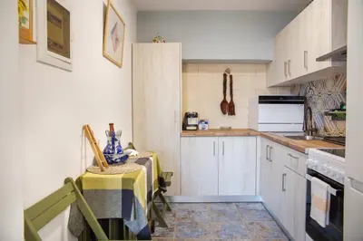 a kitchen with white cabinets and a table with chairs at Villa Romanza beach villa in Halki