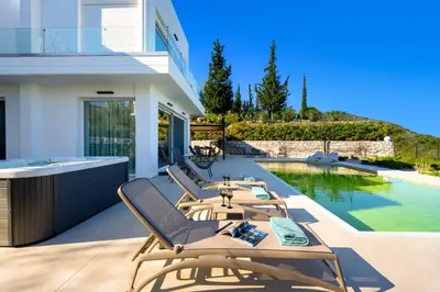 a patio with chairs and a swimming pool at Vista by Del Sol Villa in Rhodes Town