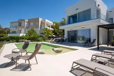 a villa with a swimming pool and chairs at Vista by Del Sol Villa in Rhodes Town