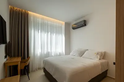 a bedroom with a bed and a desk and a window at Vista by Del Sol Villa in Rhodes Town