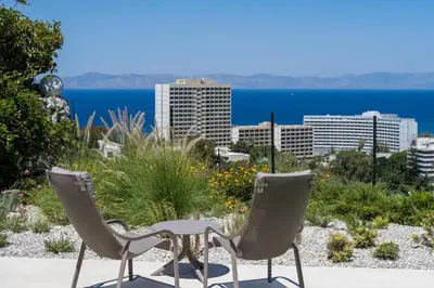 two chairs and a table with a view of the city at Vista by Del Sol Villa in Rhodes Town
