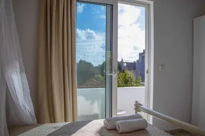 a bedroom with a large glass door to a balcony at Fotis House 3 in Afantou