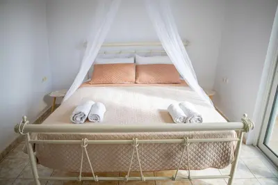 a bedroom with a bed with a mosquito net at Fotis House 3 in Afantou