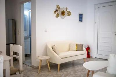 a living room with a white chair and a table at Fotis House 3 in Afantou