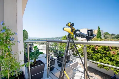 a telescope on the balcony of a house at ''Aetheria'' Rooftop Resort with sea view in Kremasti