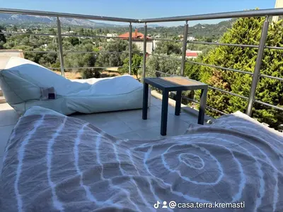a bed and a table on a balcony with a view at ''Aetheria'' Rooftop Resort with sea view in Kremasti