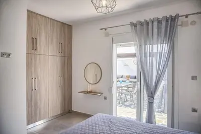 a bedroom with a bed and a mirror and a window at Haraki Acqua e Sole Ground Floor House in Haraki
