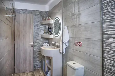 a bathroom with a sink and a mirror and a toilet at Haraki Acqua e Sole Ground Floor House in Haraki