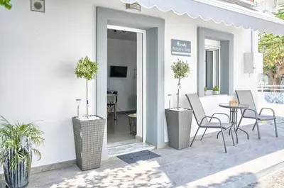 a patio with chairs and a table in a building at Haraki Acqua e Sole Ground Floor House in Haraki