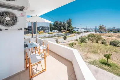 a balcony with a table and a fan at Elias Apartments with View in Rhodes Town