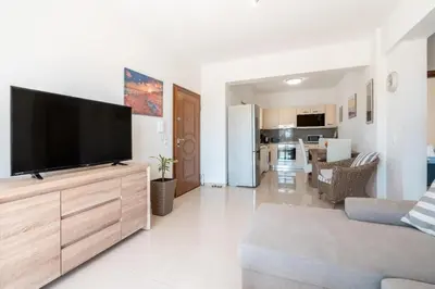 a living room with a flat screen tv on a wooden cabinet at Elias Apartments with View in Rhodes Town