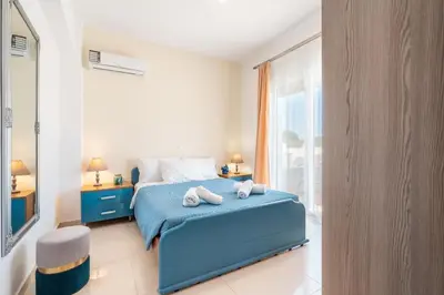 a bedroom with a blue bed with towels on it at Elias Apartments with View in Rhodes Town
