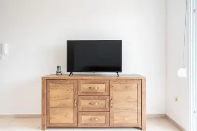 a television on top of a wooden cabinet in a room at Elias Apartments with View in Rhodes Town