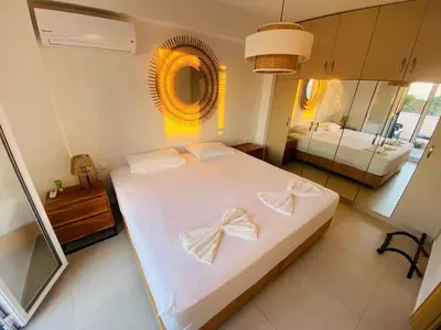 a bedroom with a large white bed with a mirror at Casa Evita in Gennadi
