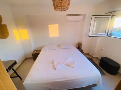 a bedroom with a white bed with a bow on it at Casa Evita in Gennadi