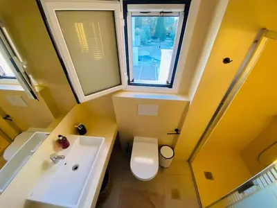 a bathroom with a sink and a toilet and a window at Casa Evita in Gennadi