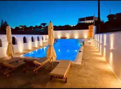a swimming pool with umbrellas and chaises on a roof at Casa Evita in Gennadi