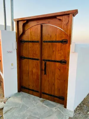 a wooden door with black hinges in a room at Casa Evita in Gennadi