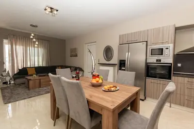 a kitchen and living room with a table with a bowl of fruit at Mary Luxury House in Émbonas