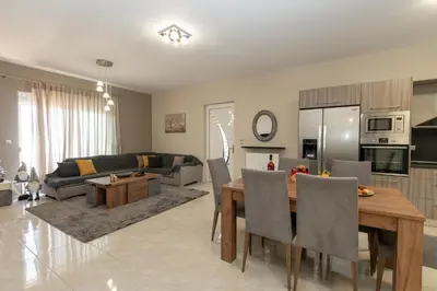 a kitchen and living room with a table and a couch at Mary Luxury House in Émbonas