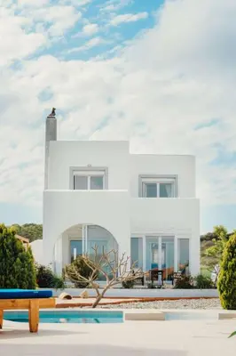 a white house with a pool in front of it at Holiday Home Gennadi Dreams Ferienvilla by Interhome in Gennadi