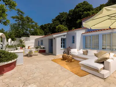 a patio with a white couch and an umbrella at Holiday Home Amelie by Interhome in Triánta