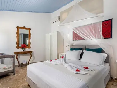 a bedroom with a bed with white sheets and red flowers on it at Holiday Home Amelie by Interhome in Triánta