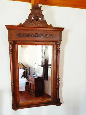 an antique mirror with a reflection of a bedroom at Villa Chrysodimi in Halki