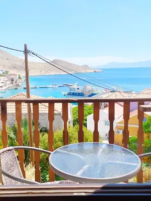 a table on a balcony with a view of the ocean at Villa Chrysodimi in Halki