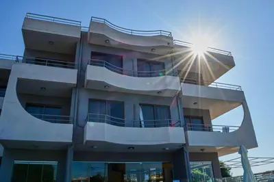 a building with the sun shining behind it at Ivory Serenity in Theologos