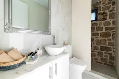 a bathroom with a sink and a toilet and a mirror at Kastro - Country Villa in Rhodes Town