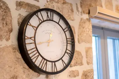 a clock on the side of a stone wall at Kastro - Country Villa in Rhodes Town
