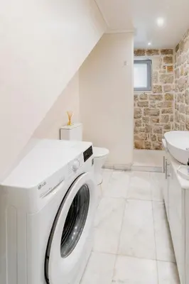 a white washing machine in a bathroom with a sink at Kastro - Country Villa in Rhodes Town