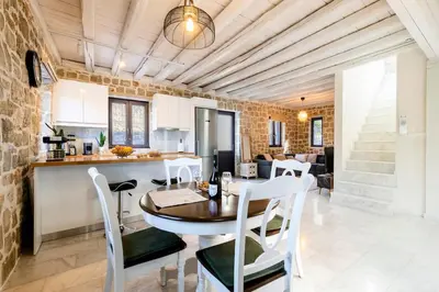 a kitchen and living room with a table and chairs at Kastro - Country Villa in Rhodes Town