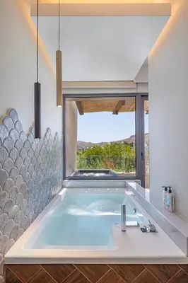 a large tub in a bathroom with a large window at Avaton Boutique Suites in Vrachonisída touArchangélou