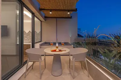 a dining room with a white table and chairs at Avaton Boutique Suites in Vrachonisída touArchangélou
