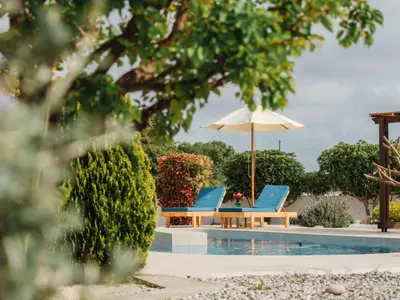 a pair of chairs and an umbrella next to a pool at Holiday Home Gennadi Dreams Ferienvilla by Interhome in Gennadi