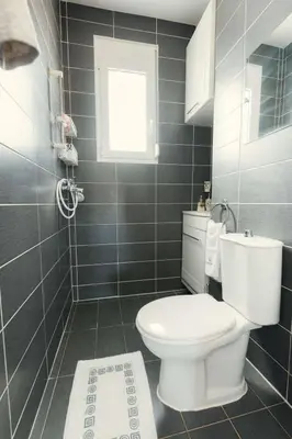 a bathroom with a toilet and a window at Holiday Home Gennadi Dreams Ferienvilla by Interhome in Gennadi