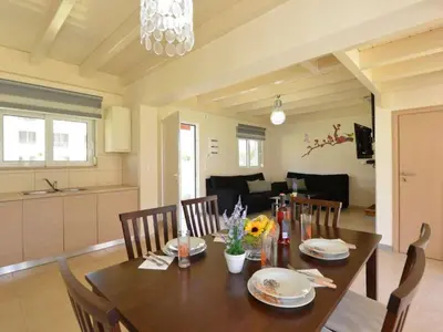 a dining table and chairs in a living room at Holiday Home Haus in Kolympia mit Garten und Bergblick by Interhome in Kolimbia
