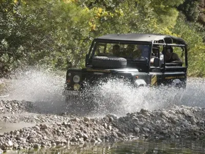 a jeep driving through the water on a river at Holiday Home Haus in Kolympia mit Garten und Bergblick by Interhome in Kolimbia
