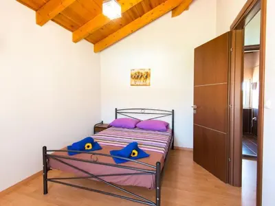 a bedroom with a bed with purple pillows at Holiday Home Haus in Kolympia mit Parkplatz und Bergblick by Interhome in Kolimbia