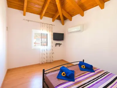 a bedroom with a bed with blue pillows on it at Holiday Home Haus in Kolympia mit Parkplatz und Bergblick by Interhome in Kolimbia