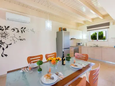 a kitchen and dining room with a table and chairs at Holiday Home Haus in Kolympia mit Parkplatz und Bergblick by Interhome in Kolimbia