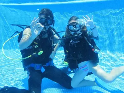 two people in the water with diving equipment at Holiday Home Haus in Kolympia mit Parkplatz und Bergblick by Interhome in Kolimbia